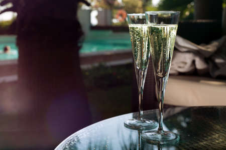 Two glasses of champagne on the glass table on black backgroundの写真素材