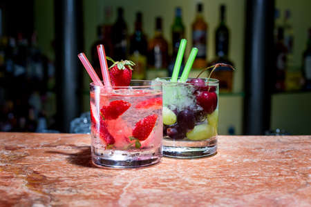 Two glasses of strawberry and grape mojitoes on marble tableの写真素材
