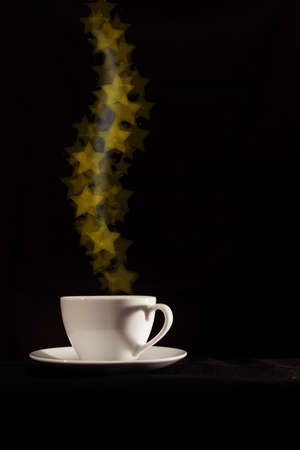 Cup with fantasy golden star shape steam on dark backgroundの写真素材