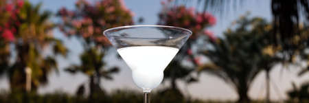 Glass of cocktail on the glass table in outdoor resort barの写真素材