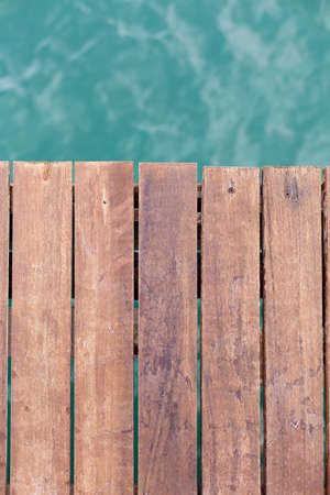 Old wooden pier backgound with sea under it