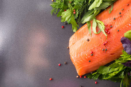 Raw salmon on a pan with salad, tomato and lemonの写真素材