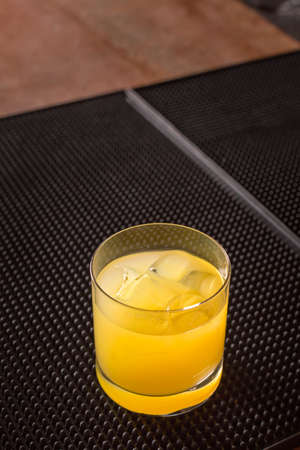 Screw driver cocktail on a bar ribber mat on dark background. Shallow DOFの写真素材