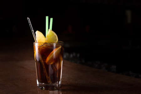 Cuba libre cocktail in a tall glass on the dark backgroundの写真素材