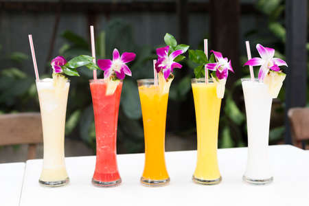 Tropical fresh juices with orchids in an outdoor restaurant. Shallow DOFの写真素材