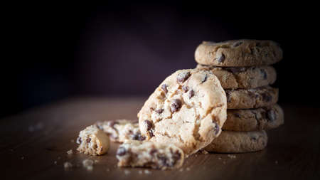 Close up of stacked chocolate chip cookies on wooden background