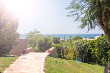 A view of park and the sea in a resort hotel. Highlighted sunshineの写真素材