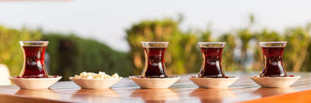 Turkish tea with locum in outdoor cafe. Direct sunset light. Shallow DOF and lightly tonedの写真素材