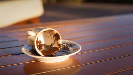 Empty cup after turkish coffee in direct sunset light - concept of traditional way of furtunetelling. Shallow DOF and lightly tonedの写真素材