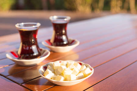 Locum and turkish tea in outdoor cafe. Direct sunset light. Shallow DOF and lightly tonedの写真素材