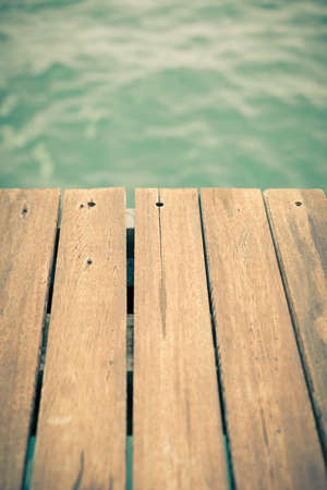 Old wooden pier backgound with sea under it. Shallow DOF and tonedの写真素材