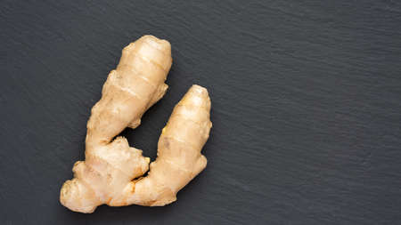 Ginger root on a dark stone background. Shallow DOFの写真素材