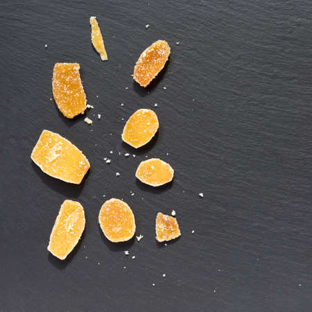 Crystallized ginger root on a dark stone background. Shallow DOFの写真素材