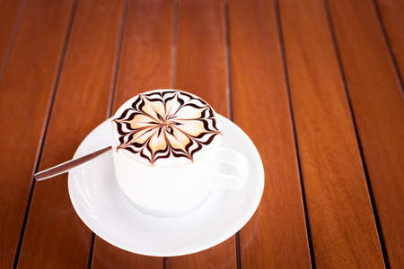 A cup of cappuccino on a wooden surfaceの写真素材