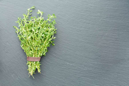 A bunch of fresh thyme on a dark stone backgroundの写真素材