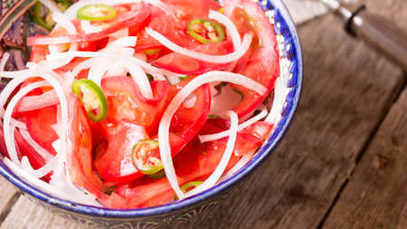 Pilaf and achichuk salad in handmade plate with antique forks on wooden background.の写真素材