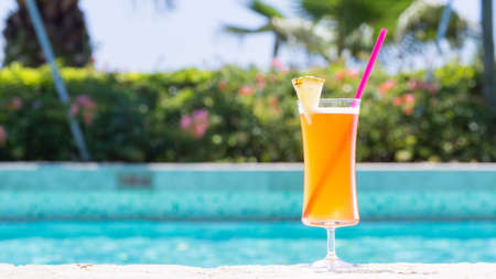 Glass of Mai Tai cocktail on the pool nosing at the tropical resort. Horizontal, wide screen, cocktail on right sideの写真素材