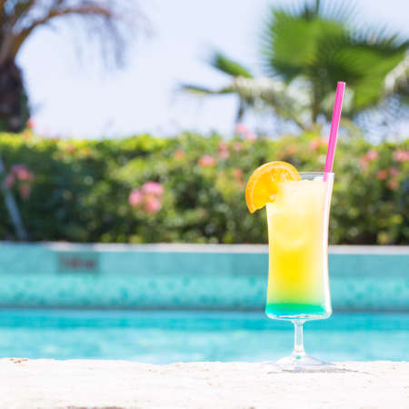 Glass of Happy days non alcohol cocktail on the pool nosing at the tropical resort. Square, cocktail on right sideの写真素材
