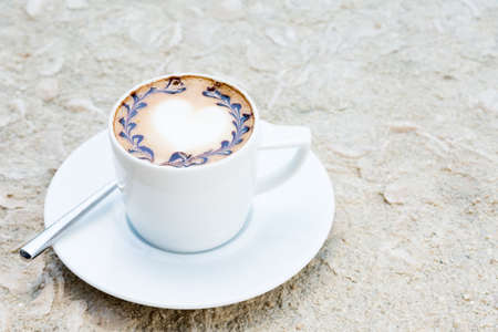 Side view of cafe latte with topping on it. Standing on sand. Horizontalの写真素材