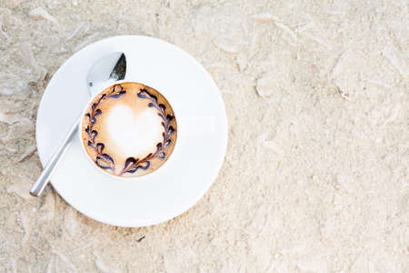 Overhead view of cafe latte with topping on it. Standing on sand. Horizontalの写真素材