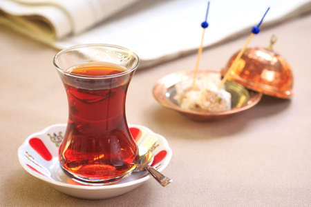 Cup of turkish tea with locum on oriental plate. Concept of turkish tea. Beige tablecloth...