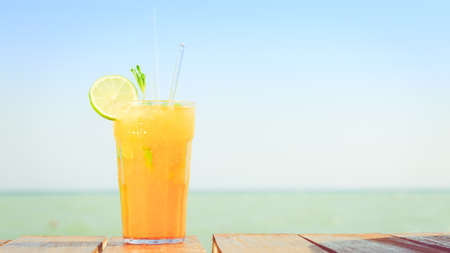 Mango mojito on the wooden pier with blue sky. Concept of luxury tropical vacation. Classic...