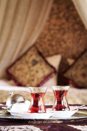 Two turkish tea cups and turkish delight with oriental canopy bed at the background. Silver tray. Romantic concept. Valentines background. Arabian nights ambiance. Verticalの写真素材