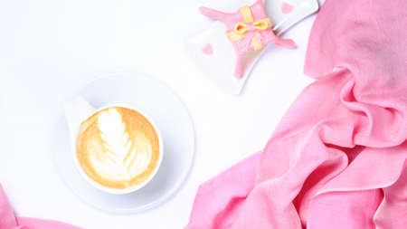 Coffee with pink scarf. Valentines concept. White background. Light, modern style. Gift style cake and heart shape sprikles. Warm tone. Horizontal, wide screenの写真素材