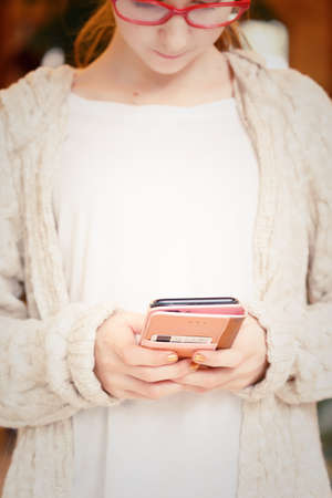 Teenage girl working on a smartphone. Modern technologies and remote work concept. White and beige...