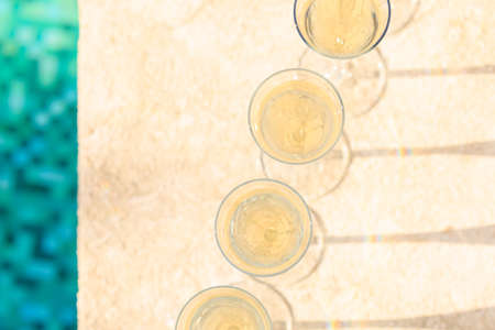 Many glasses of champagne or prosecco near resort pool in a luxury hotel. Pool party. Top view, flat layout. Horizontalの写真素材