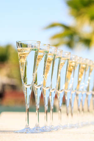 Many glasses of champagne or prosecco near resort pool in a luxury hotel. Pool party. Verticalの写真素材