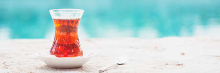 Hot turkish tea outdoors near water. Turkish tea and traditional turkish culture concept. Horizontal, banner format. Toned imageの写真素材