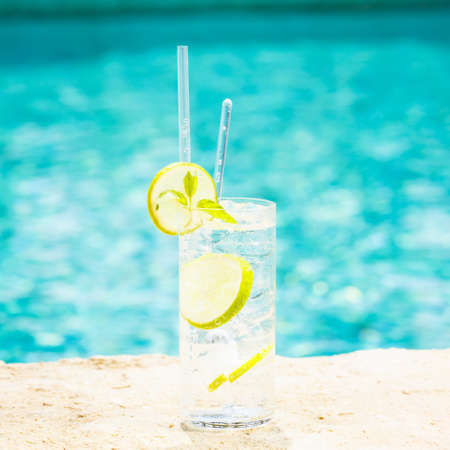 Water with ice at the edge of a resort pool. Concept of luxury vacation. Outdoor pool background....