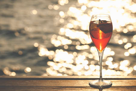 Aperol spritz at a wooden pier at sunset. Luxury resort vacation concept. Festive relax getaway background. Horizontal, toned imageの写真素材