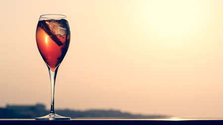 Aperol spritz at a wooden pier at sunset. Luxury resort vacation concept. Festive relax getaway background. Toned image. Horizontal, wide screen formatの写真素材