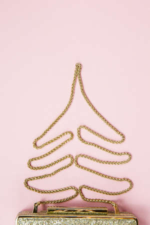 Festive evening golden clutch with star sprinkles on pink. Holiday and celebration background. Luxury accessories and party concept. Christmas and New Year Celebration. Verticalの写真素材