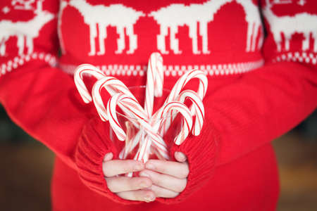 Girl holding stack of peppermint candy canes. Christmas holiday concept. Holiday background. Horizontalの写真素材