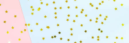 Golden star sprinkles on double pink and blue. Festive holiday background. Celebration concept. Top view, flat lay. Horizontal, banner formatの写真素材