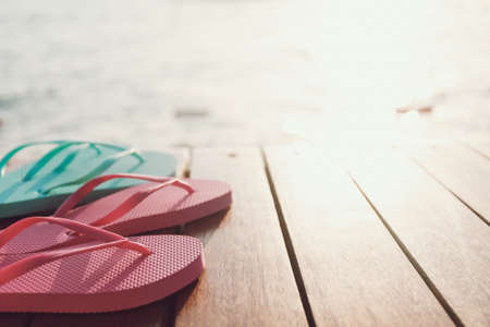 Flip flops at the pier at the sunset. Horizontal