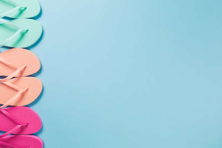 Raw of flip flops on the blue background. Horizontalの写真素材