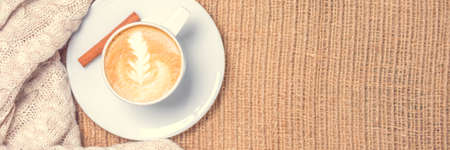 Cup of coffee or chai tea with latte art. Leisure time concept. Pastel colors, warm toning. Horizontal, banner formatの写真素材