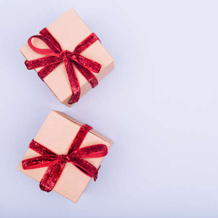 Craft box with red ribbon bow. Valentine day concept. Trendy minimalistic flat lay design...