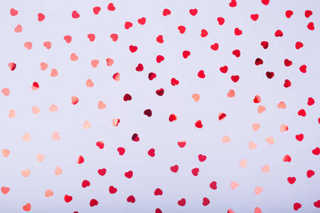 Grey background with red glitter heart confetti. Valentine day concept. Trendy minimalistic flat lay design background. Horizontalの写真素材