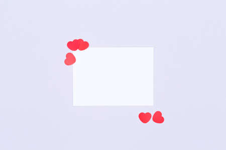 White card with glitter heart confetti. Valentine day concept. Trendy minimalistic flat lay design background. Horizontal, white mockupの写真素材