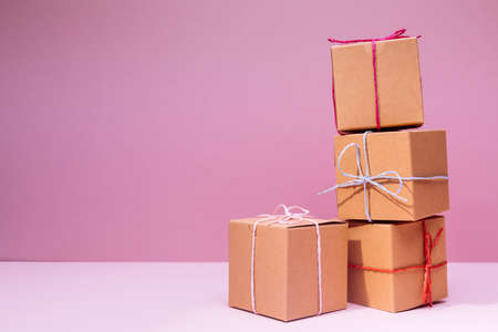 Craft cardboard boxes on the solid pink background. Holiday and gift concept. Horizontalの写真素材
