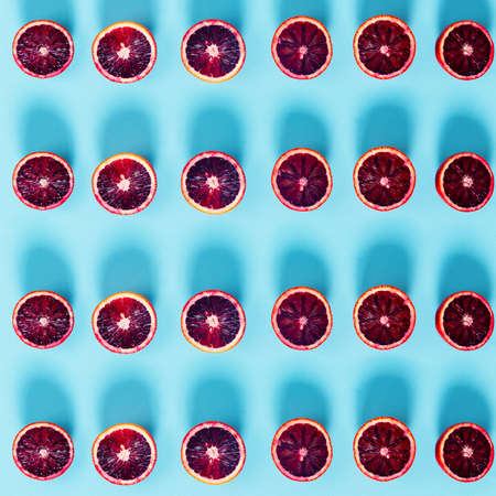 Red oranges on the bold blue background. Creative minimalism and modern food pattern concept. Square