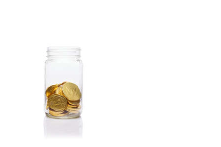 Glass jar with medium amount of  gold coins. Moderate level  of savings.  Savings and wealth management concept Horizontalの写真素材