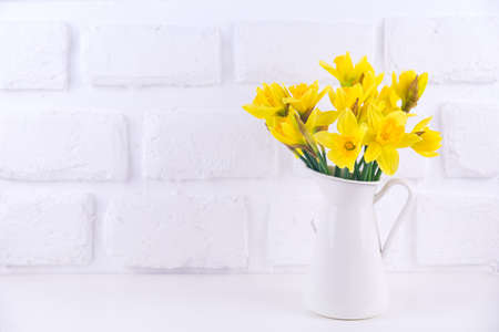 Jar with narcissuses at the white background. Horizontal Spring, mothers day and easter conceptの写真素材