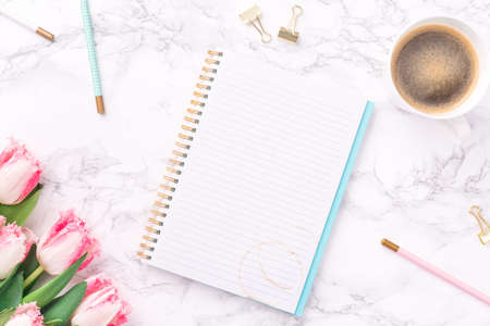 Pink tulips with festive stationary and coffee on white marble background. Feminine job, gender equality, home office and career concept. Copy space Top view. Horizontalの写真素材