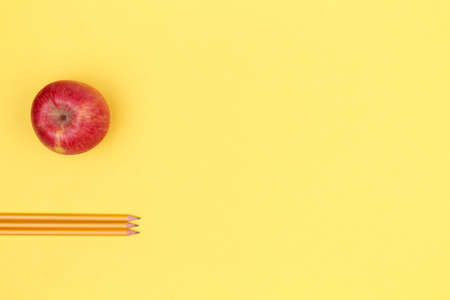 Pencils and apple on a yellow background. Back to school concept. Horizontalの写真素材